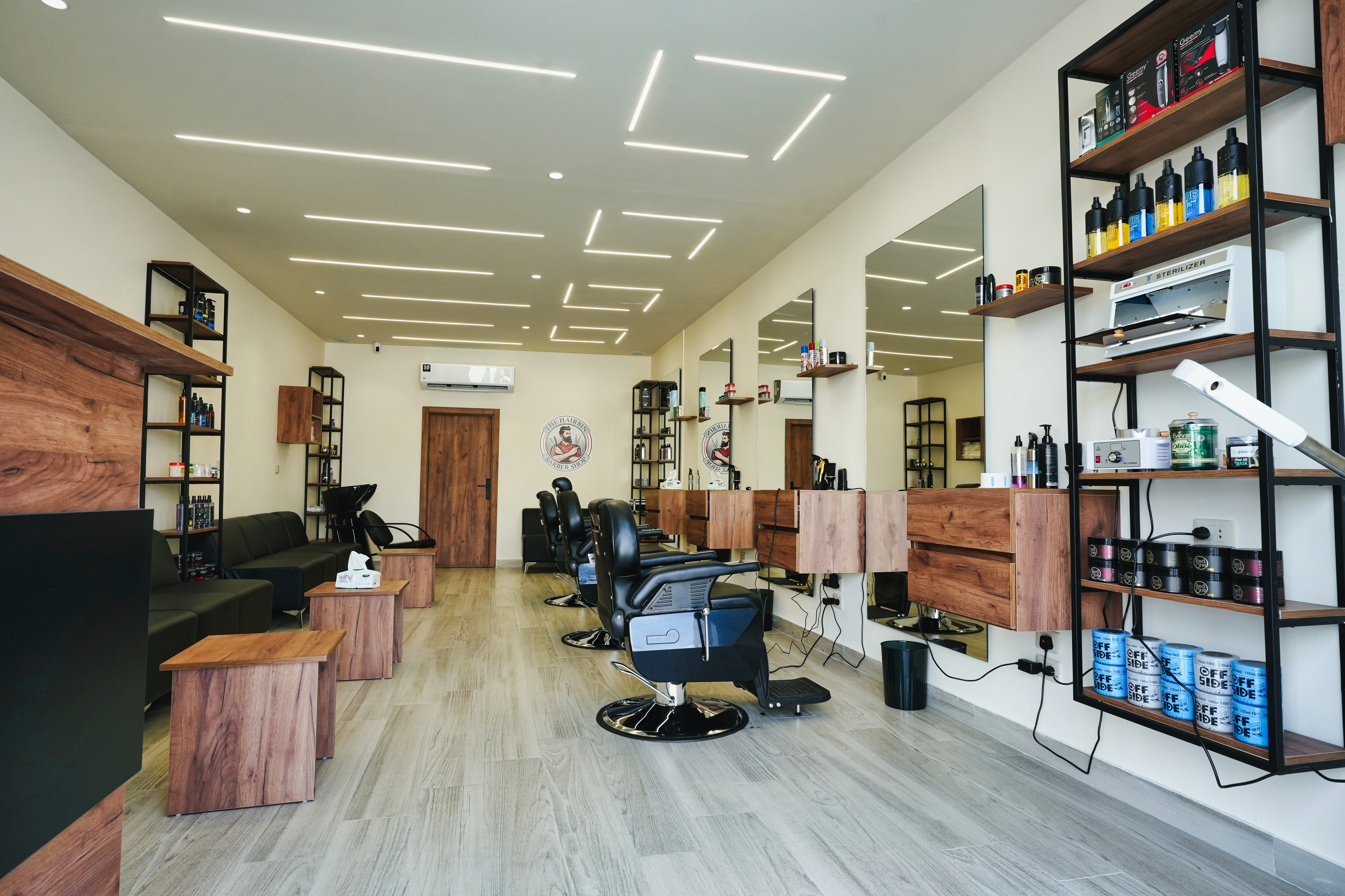 The Hairbin Barber Shop interior with a geometric LED ceiling and warm wood styling stations