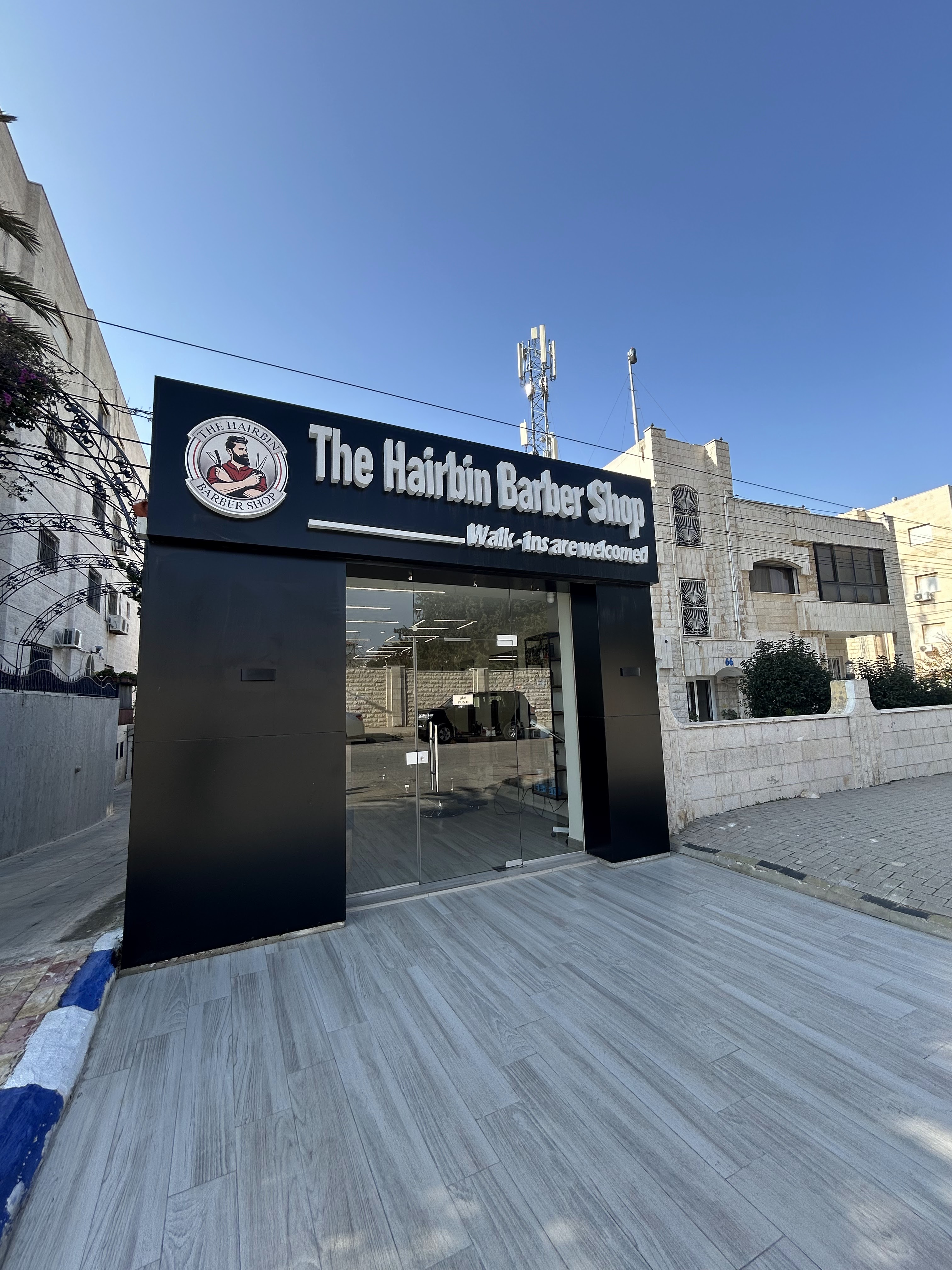 The Hairbin Barber Shop storefront with its circular logo sign